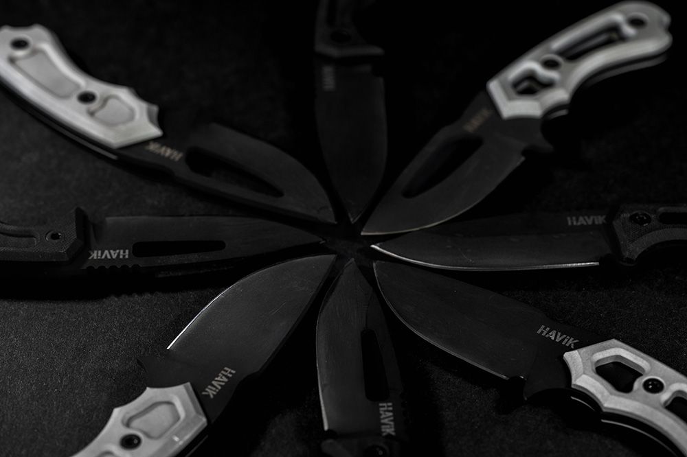 Eight HAViK fixed-blade knives arranged in a radial fan on a dark surface
