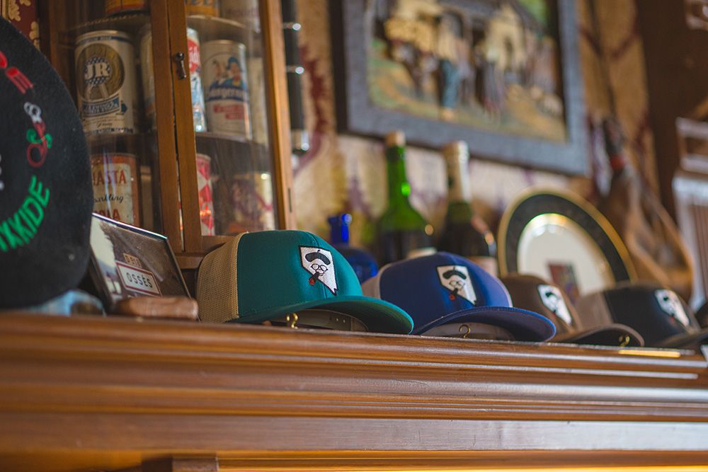 JT Basque trucker caps with Nevada-shaped logo patches on a wood mantel