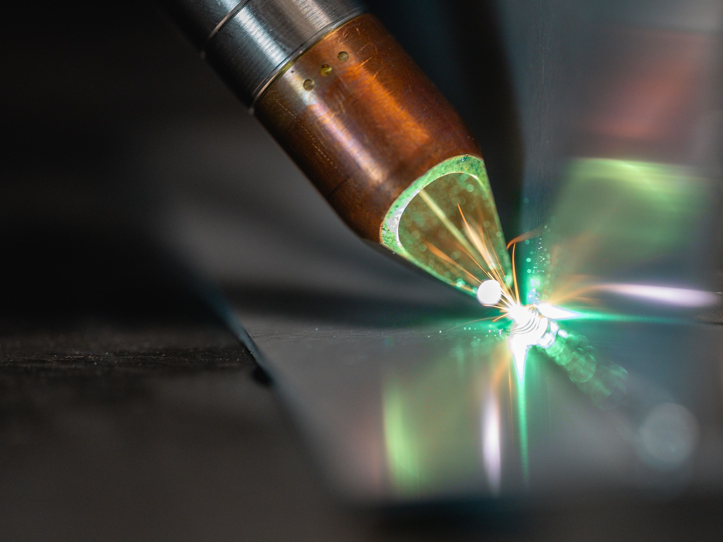 Close-up of plasma arc cutting stainless steel plate in a fabrication shop
